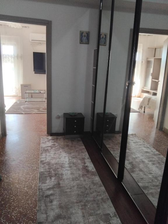 a room with a mirror and a living room with a table at Eclisse quinto piano senza ascensore in Palermo
