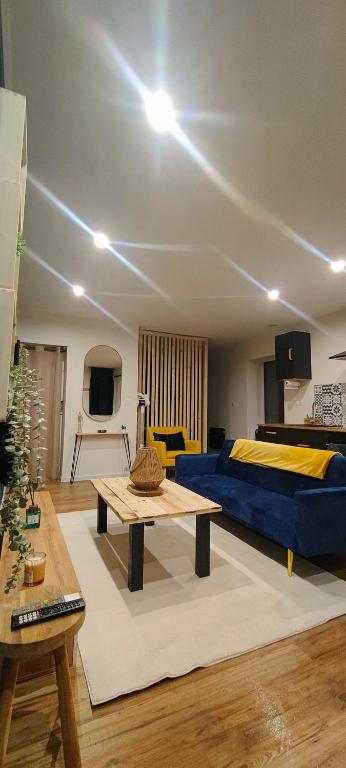 a living room with a bed and a table at OasisNoir in Calonne-Ricouart