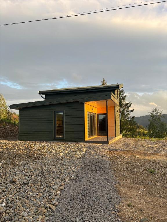 a small house sitting on top of a gravel road at Evergreen cottage in Slavske