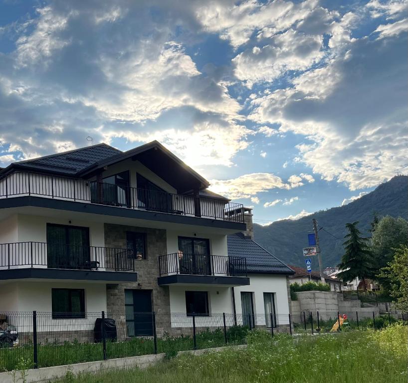 a building with balconies and a sky with clouds at Guest House ELIYA in Devin