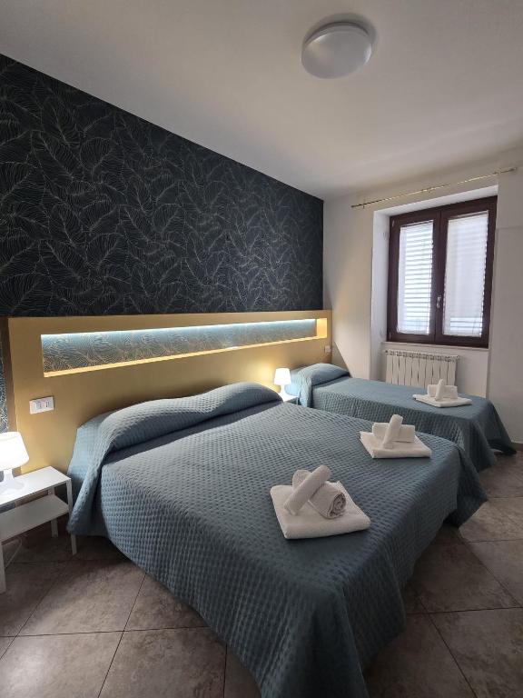 two beds with towels on them in a bedroom at B&B Sant'Anna in Lercara Friddi