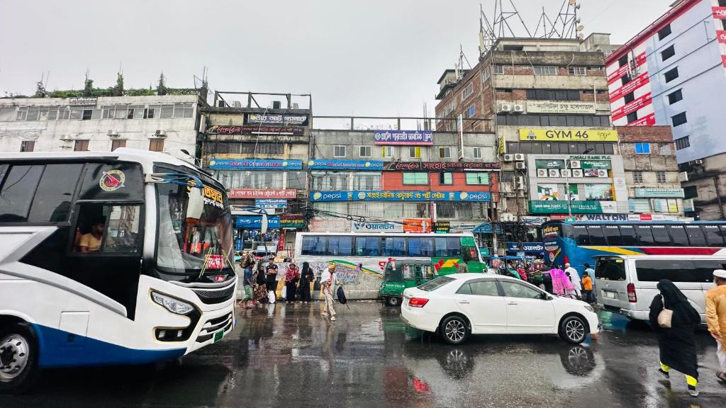 a bus and a car on a busy city street at Hotel Paradise Residential in Dhaka