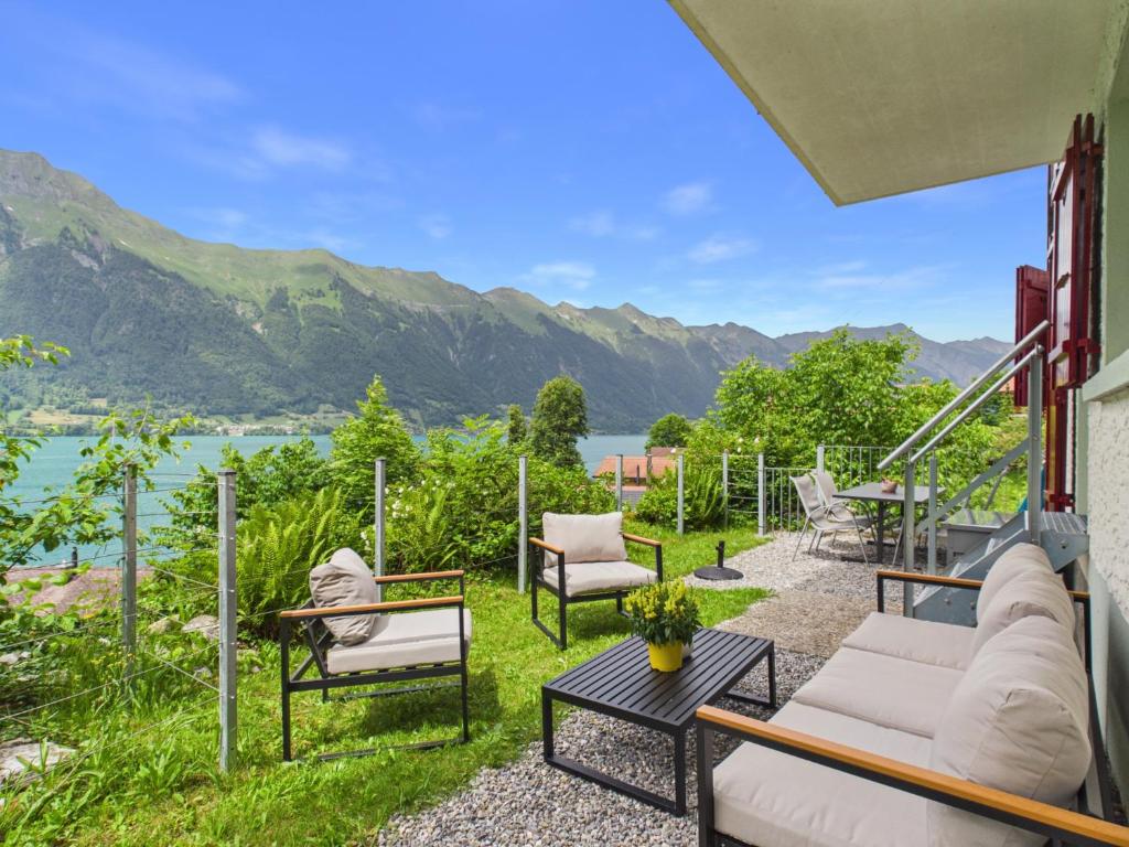 a patio with a view of the water and mountains at Guardian Gate Lodge in Iseltwald