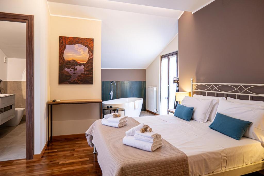 a bedroom with a large bed and a bath tub at La Ginestra in Fiore Camere in Sirolo