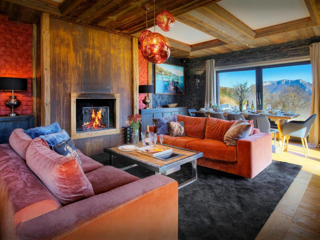 a living room with two couches and a fireplace at Chalet Kalyssia - OVO Network in Saint-Jorioz