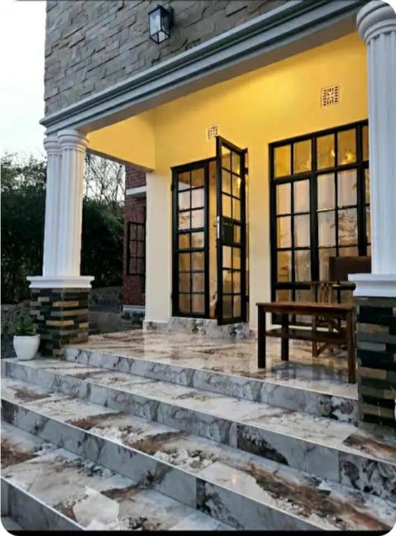 a front porch of a house with a bench on it at pumzika hill in Arusha