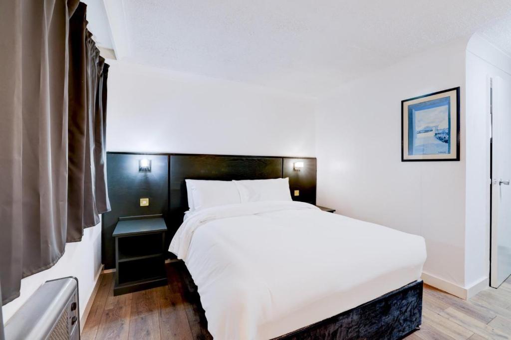a bedroom with a large white bed and a window at The Rivenhall Hotel in Rivenhall