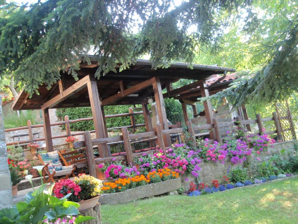 a wooden gazebo with a bunch of flowers at Agriturismo Flora in Chiusi della Verna