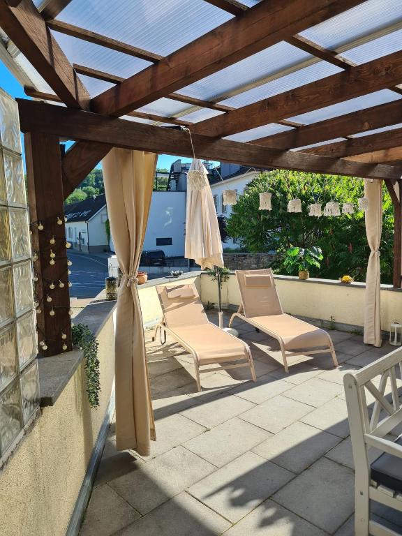 a patio with chairs and a wooden pergola at Ferienwohnung Sonne in Schliengen
