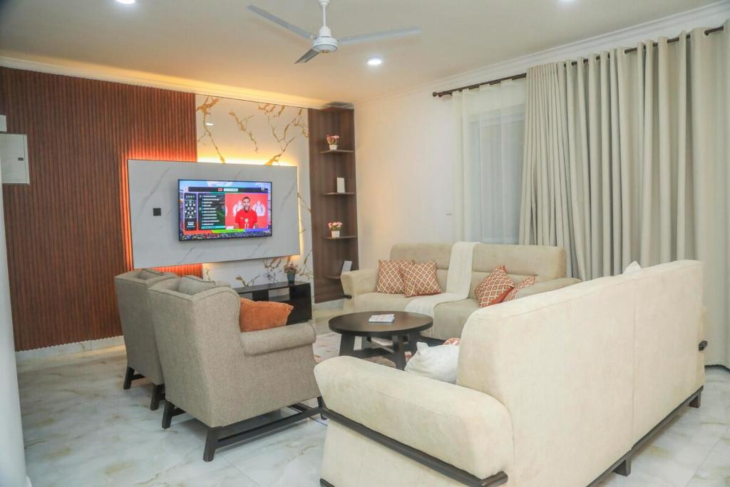 a living room with couches and a flat screen tv at Coastal Haven 3 Bed Nyali in Mombasa