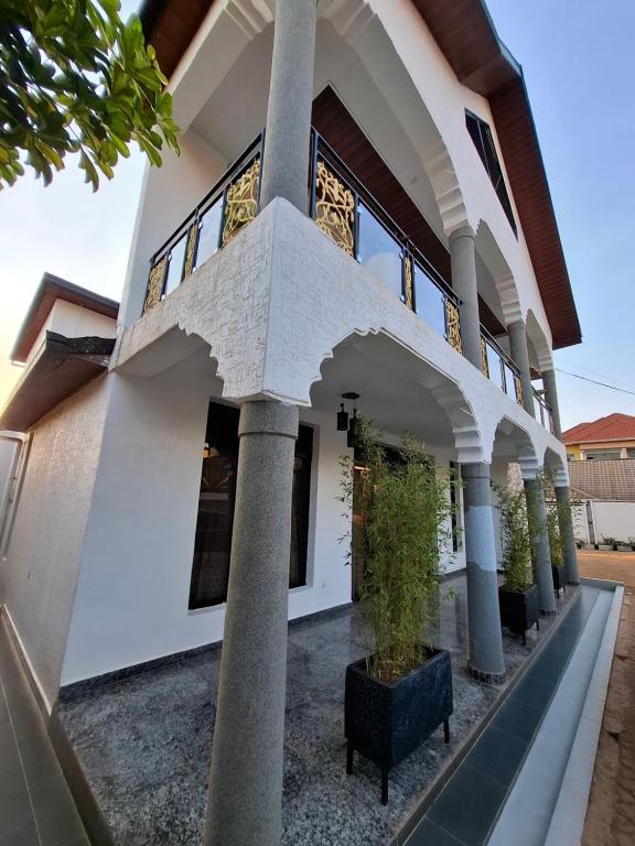 a house with columns and a courtyard at Kigali Alba Home in Kigali