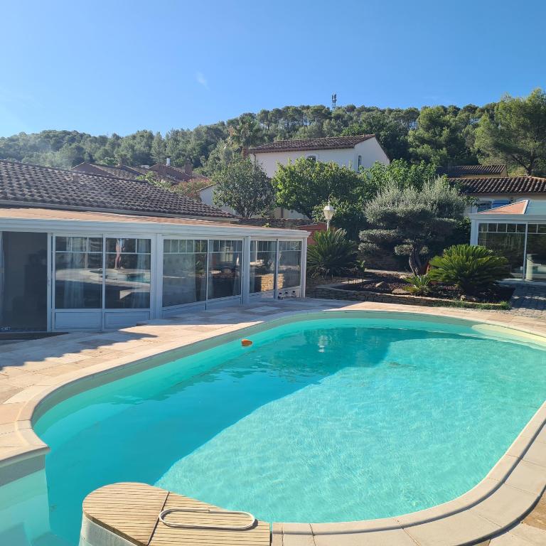 a swimming pool with blue water in a house at Sunny house in Pierrefeu-du-Var