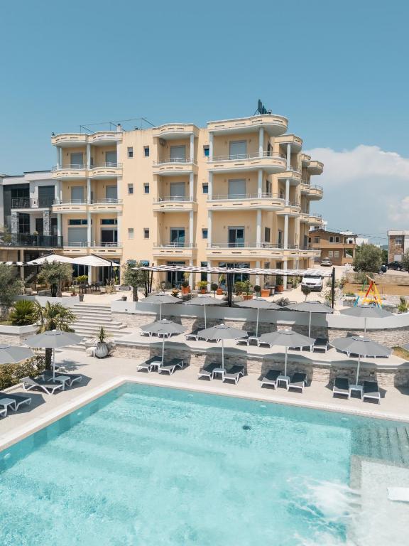 a hotel with a swimming pool in front of a building at Hotel Blue Moon in Ulcinj