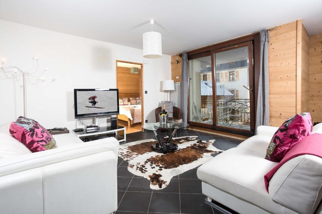 sala de estar con 2 sofás blancos y TV en Le Paradis 24 apartment - Chamonix All Year, en Chamonix-Mont-Blanc
