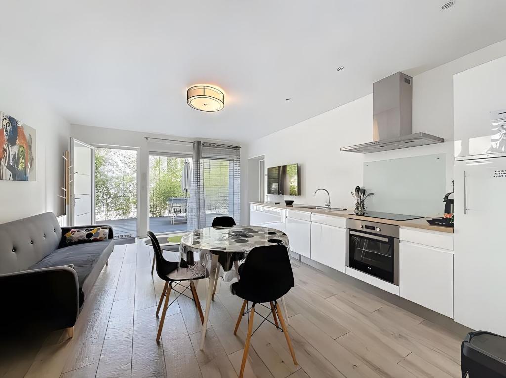 a kitchen and living room with a table and chairs at Gite Leny proche Colmar in Ingersheim