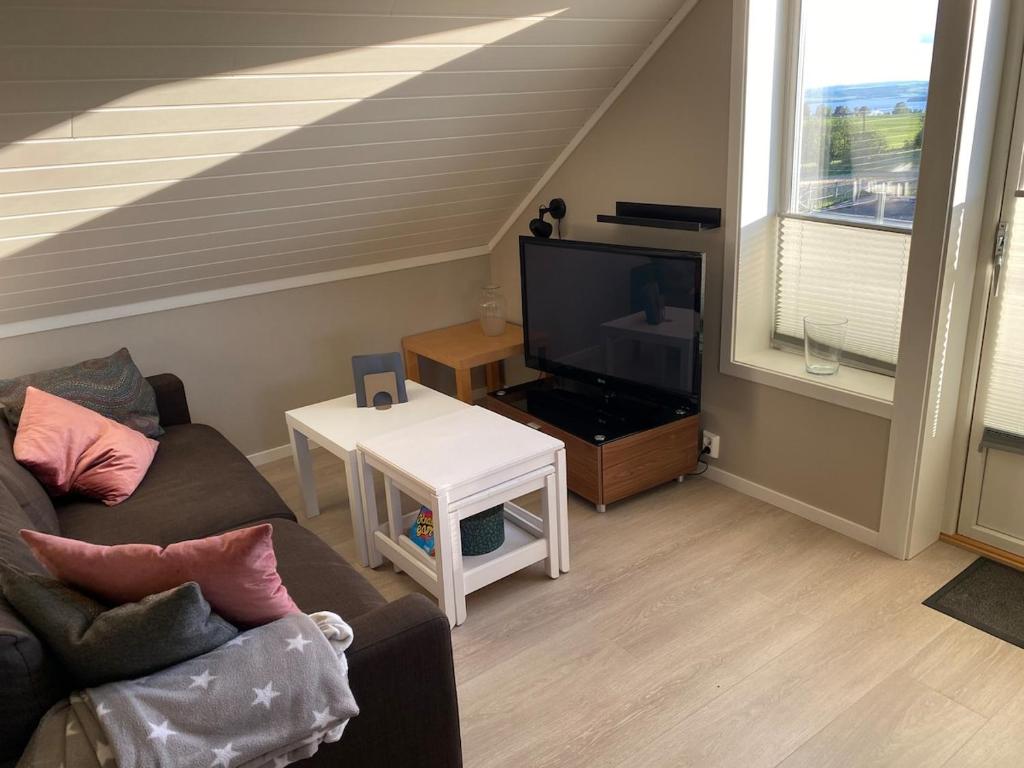 a living room with a couch and a tv at Apartment in beautiful Stange in Stange