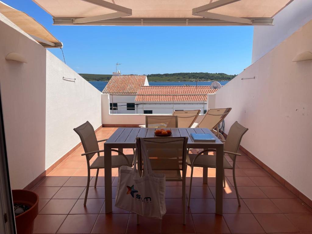 a balcony with a table and chairs on a roof at Riera Rossello 2 by SOM menorca in Fornells