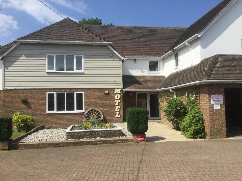 a house with a brick driveway in front of it at T & J Motel in Lamberhurst