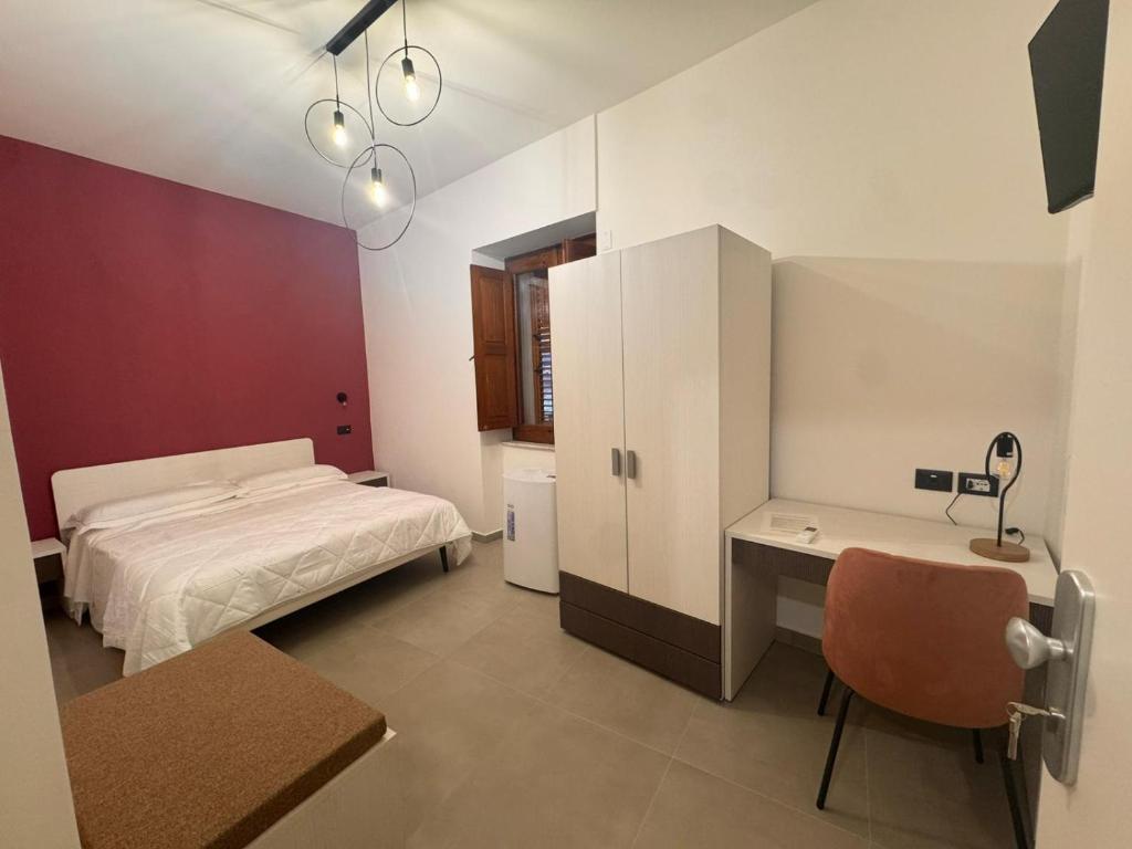 a bedroom with a bed and a desk with a chair at B&b Al Castello in Gerace