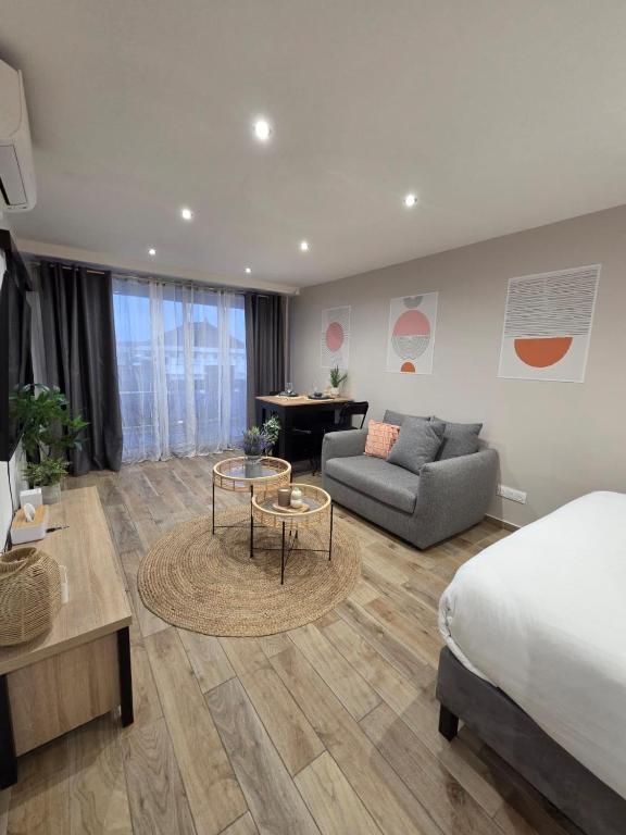 a bedroom with a bed and a couch and a table at Studio cosy devant RER B TGV Massy SNCF in Massy