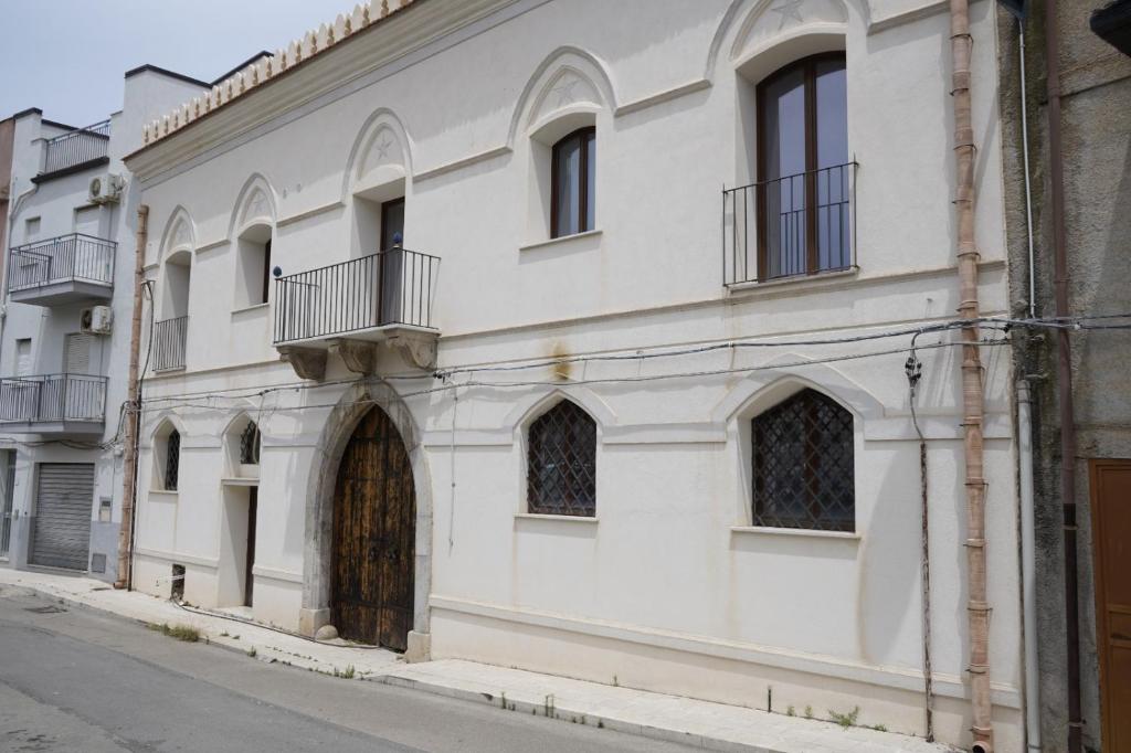 a white building with a door on a street at L'antica Dimora Fronte Mare in Finale