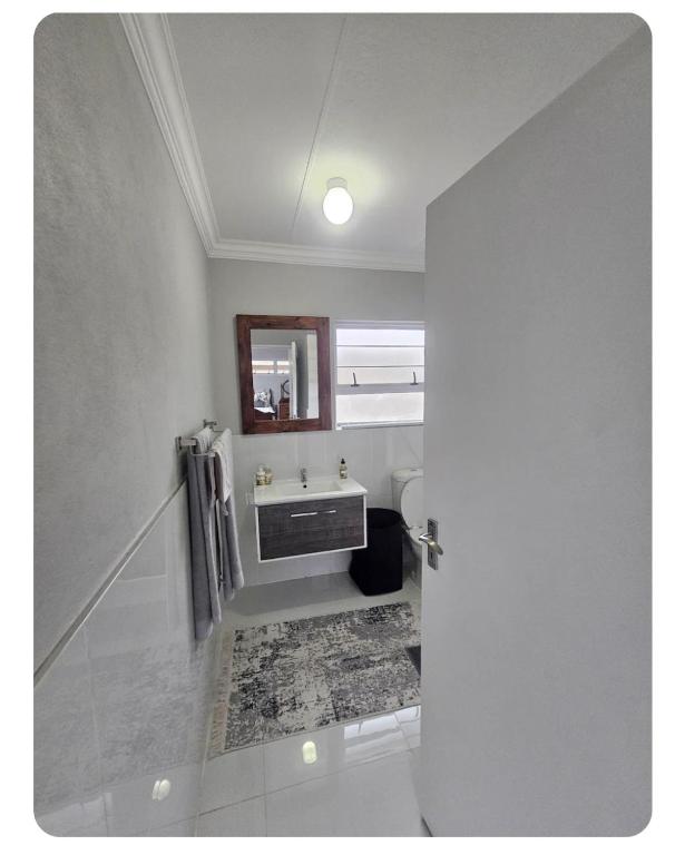 a bathroom with a sink and a mirror at StayAtGoethe in Secunda