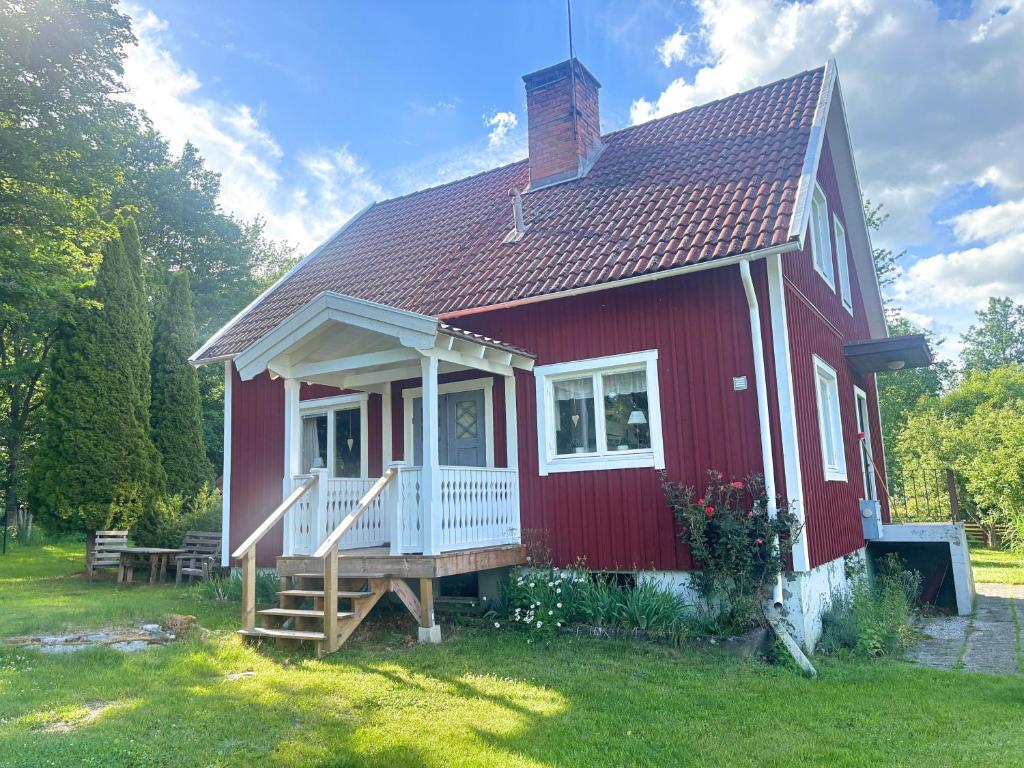 a red house with a porch and a deck at Hus Hornsö in Blomstermåla