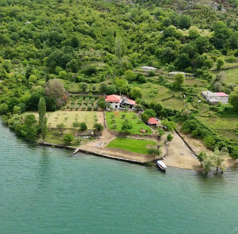 an island in the water with a house and a boat at N'Gegaj Villa in Shkodër
