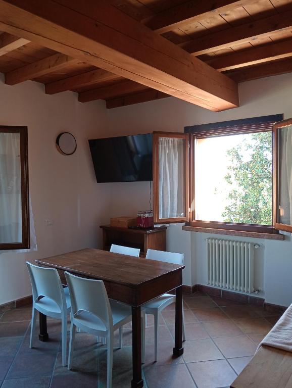 a dining room with a table and chairs and a television at Casa LB14 in Castelletto Borgo