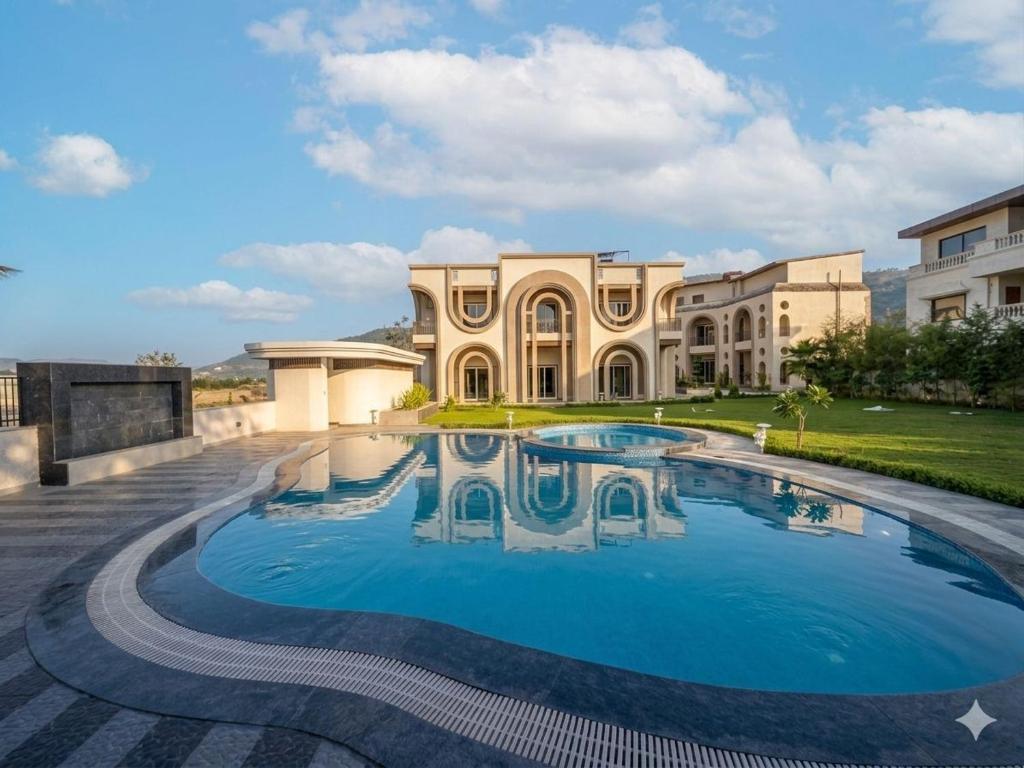 a large house with a swimming pool in front of it at Oryana Resort in Udaipur