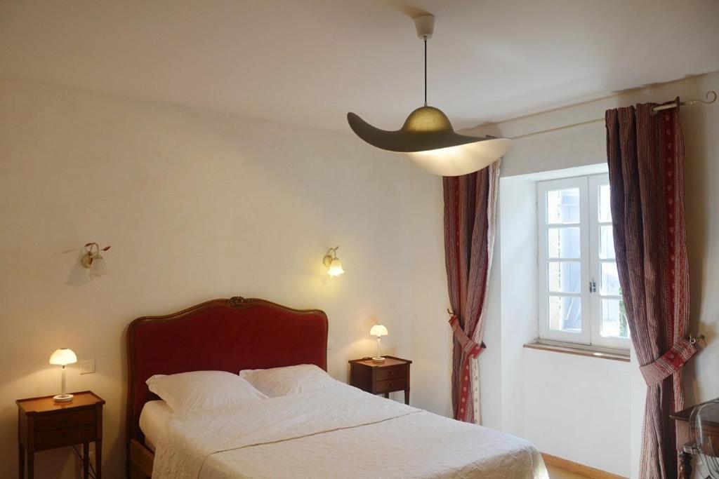 a bedroom with a bed and a large window at Chambre dhôtes au pigeonnier in Poulan-Pouzols