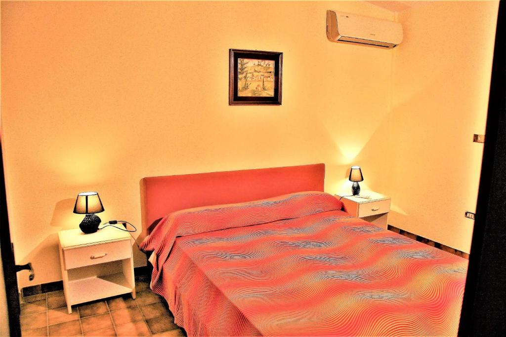 une chambre avec un lit rouge et deux tables de nuit dans l'établissement Happy Holiday Villa, à Syracuse 24 autres photos