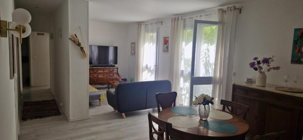 a living room with a table and a blue chair at Le lilas d orly in Orly
