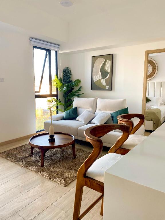 a living room with a couch and a table at Apartamento Moderno z 10-Jacuzzi-Lavandería-AC-Gym-GuatemalaCity in Lo de Contreras