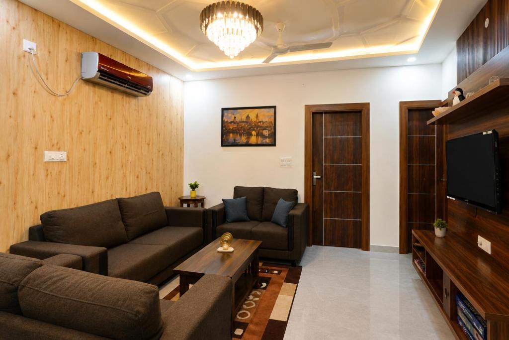 a living room with two couches and a tv at Thecrestoria in Dehradun