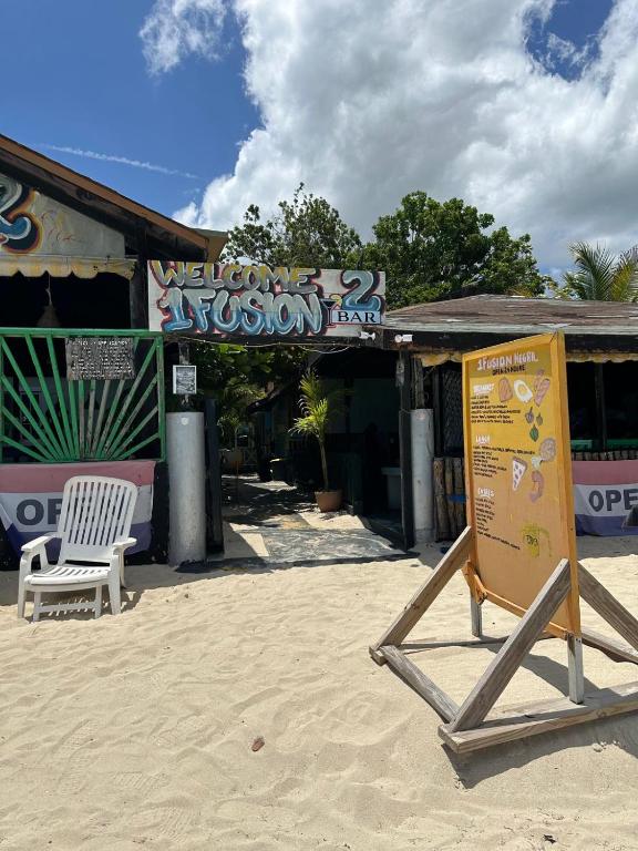 a sign in the sand in front of a store at 1Fusion2 in Negril