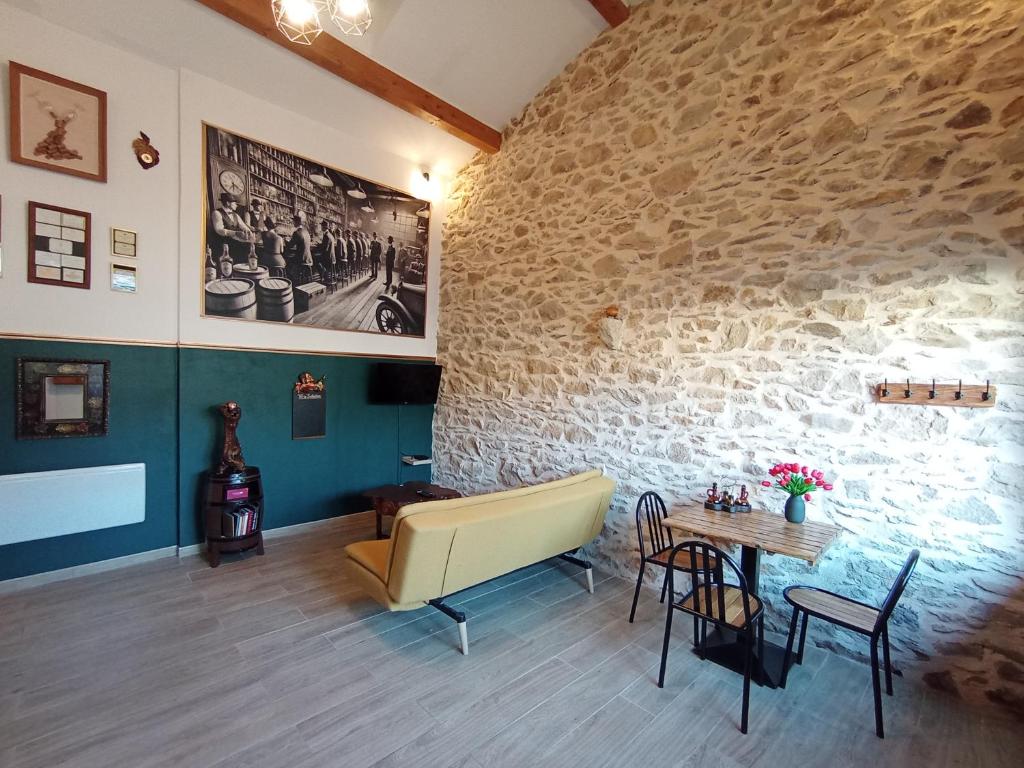 a room with a table and a stone wall at La Pépite du Sauternais in Preignac