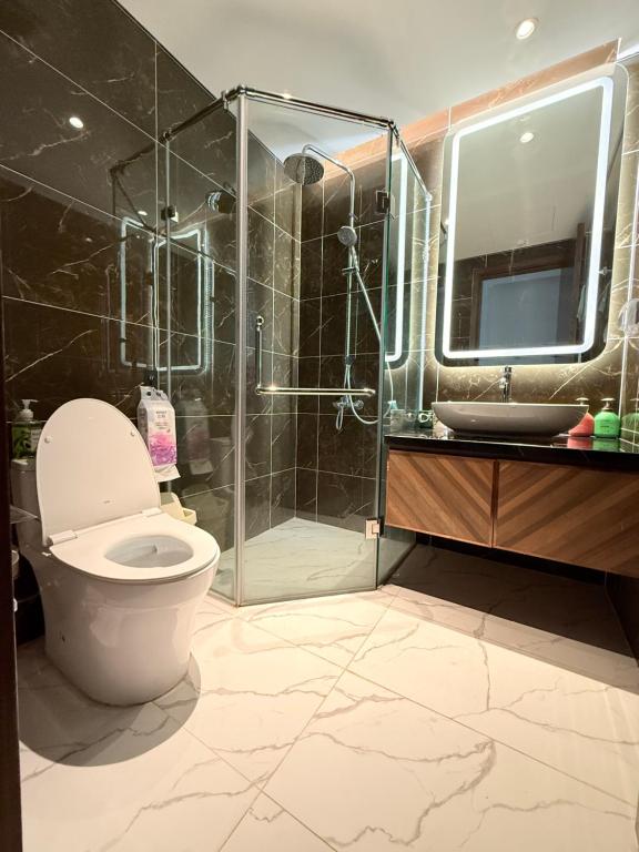 a bathroom with a toilet and a glass shower at Mai home in Hai Phong