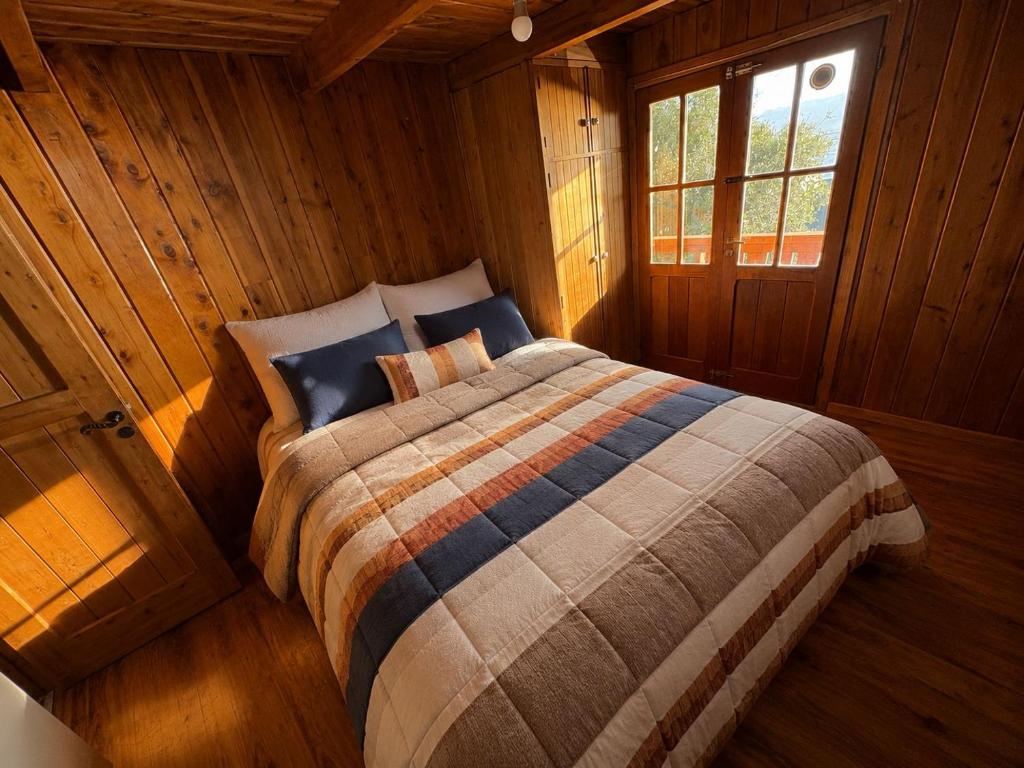 a bedroom with a bed in a wooden cabin at Olly Patagonia Suites in San Carlos de Bariloche