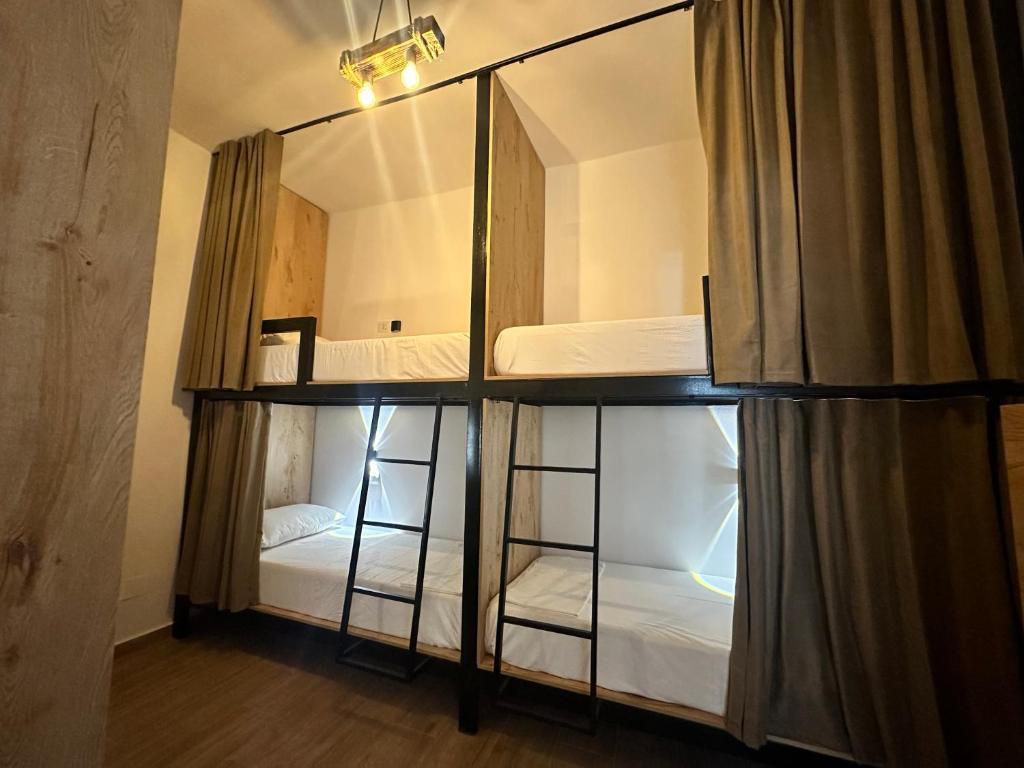 a room with two bunk beds and a mirror at Bume's Hostel in Sarandë