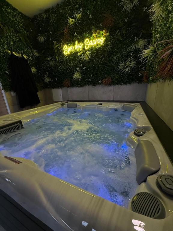 a jacuzzi tub in a building with a sign at Spa des Sacres - Suite avec Jacuzzi Privatif in Reims