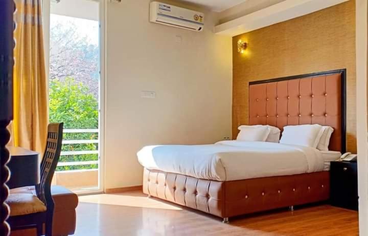 a bedroom with a large bed and a large window at Craviq Hotels -1 in Ghaziabad