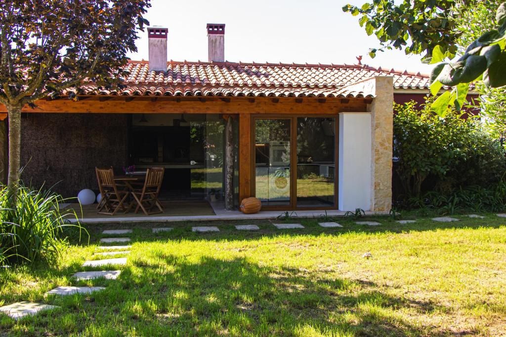 a house with a patio with a table and chairs at d'Olívia Lovely Homes in Cela
