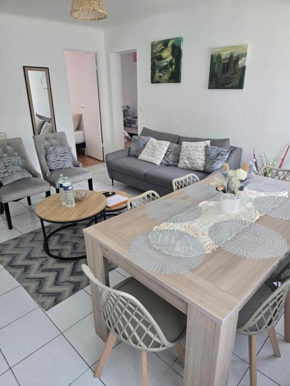 a living room with a table and a couch at Séjour Eau Vive Proche commerces et Metro in Créteil