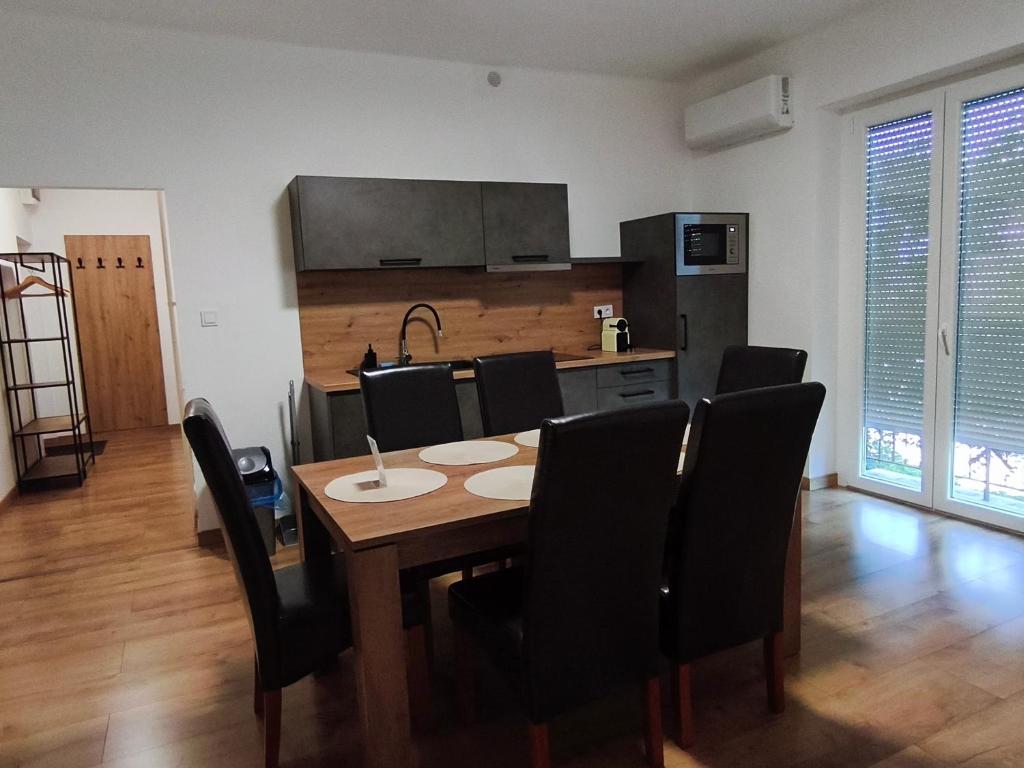 a kitchen and dining room with a table and chairs at Central Apartman Tatabánya in Tatabánya