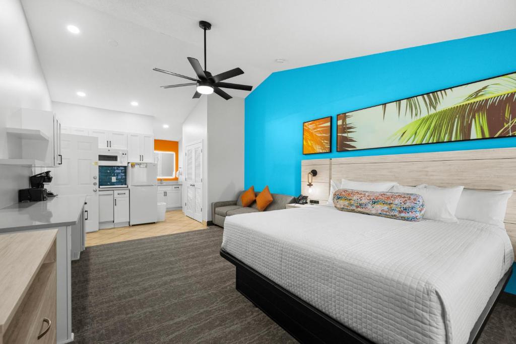 a bedroom with a white bed and a blue wall at Grand Palms Resort in Myrtle Beach