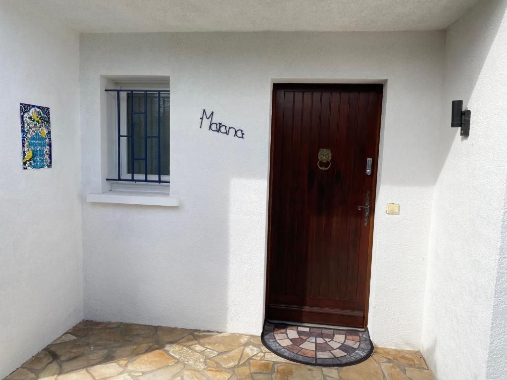 a brown door in a white wall with a window at Agréable Maison basque-Anglet in Anglet