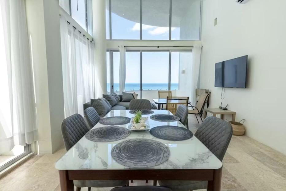 a living room with a table and a couch at Oceanfront Condo with Pool and Views Telchac | Depto B52 in Xtampú