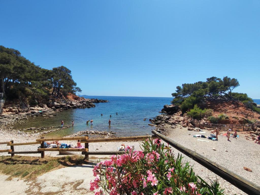 a beach with people swimming in the water at Villa du Capelan - BANDOL in Bandol