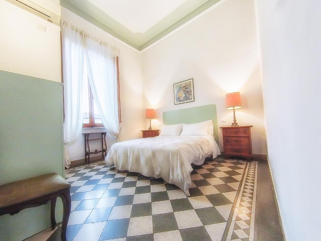 ein Schlafzimmer mit einem Bett und einem karierten Boden in der Unterkunft Villa Gini in Pisa